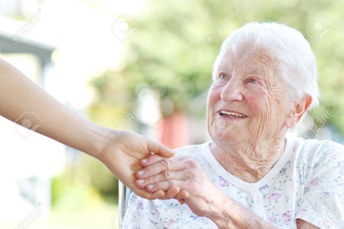 14396894-Happy-senior-woman-holding-hands-with-caretaker-Stock-Photo-elderly-people-old