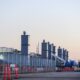 Data center construction site with fenced perimeter, crane, exhaust stacks, and equipment, showing active development of secure technology infrastructure for computing, storage, and network operations